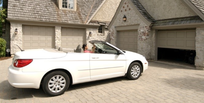 Convertible in front a garage