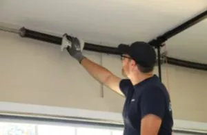Man lubricating Torsion Spring on a garage door